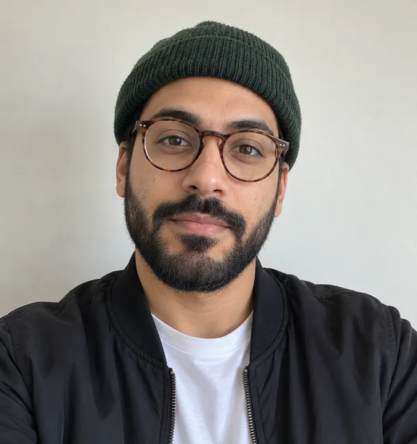 Input selfie: a bearded man in glasses, a green beanie and a bomber jacket